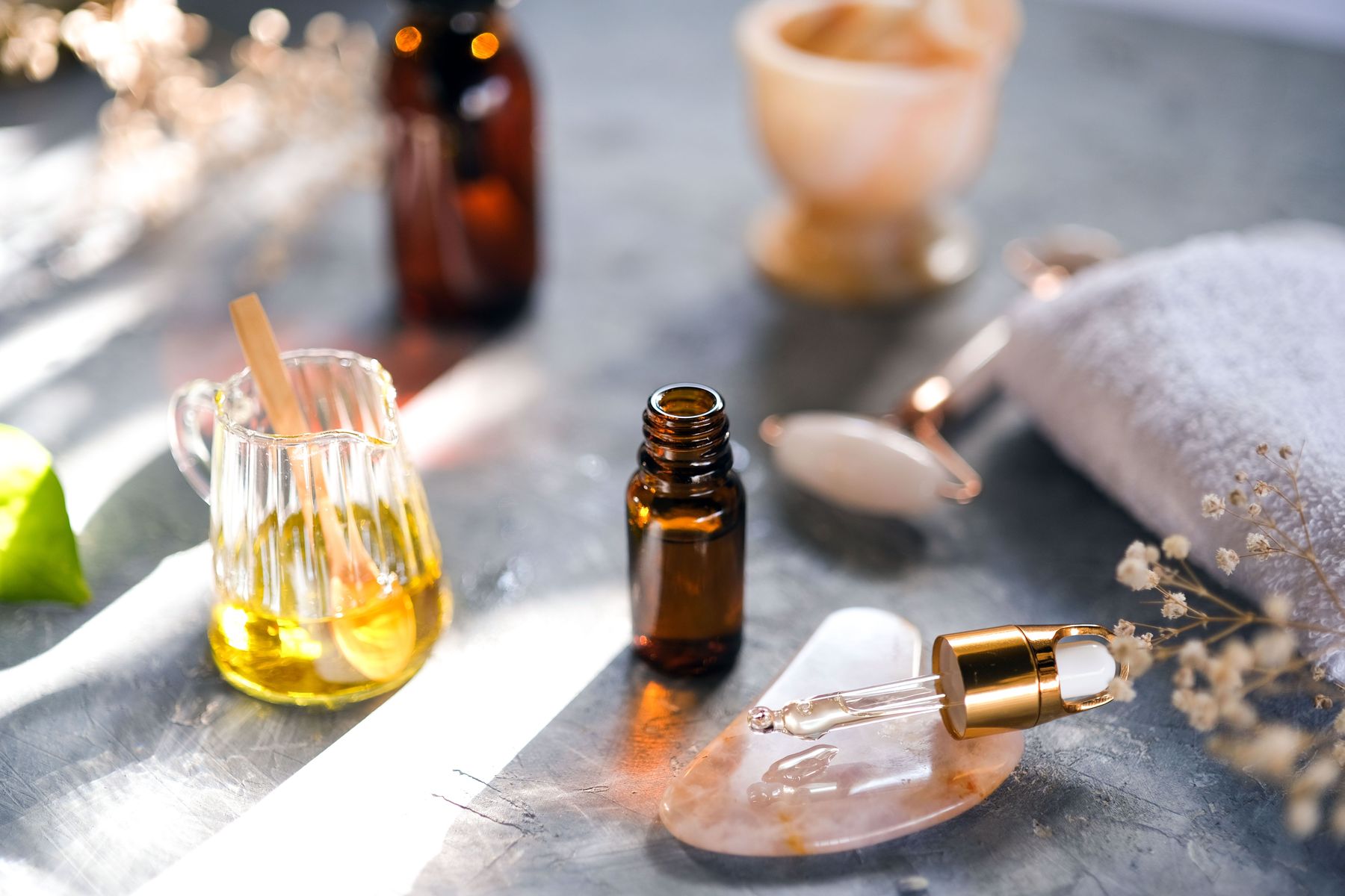 Warm massage oils, stones and linen in afternoon light