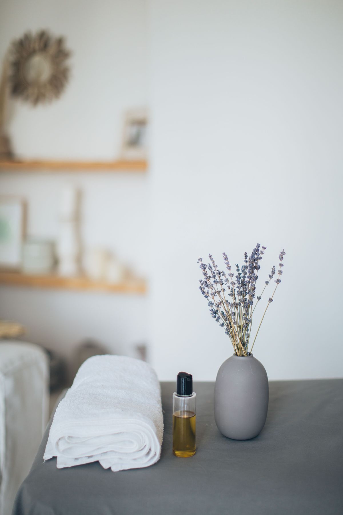 A quiet corner of the clinic — pressed towels, massage oil and dried lavender